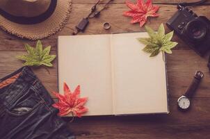 Maple leaf on wooden background at summer and notebook for your text photo