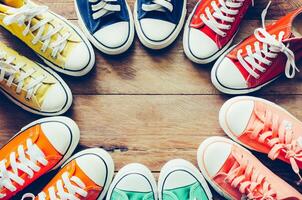 Multi Color sneakers on wood background photo