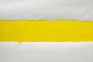 The paper is torn on a yellow background and there is a cutoff to the free space for your text. photo