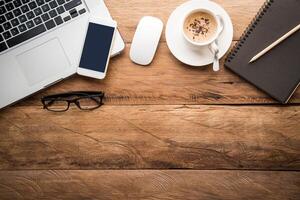 Top view with copy space, working desk with laptop,cellphone,notebook pencil and coffee in the office. photo