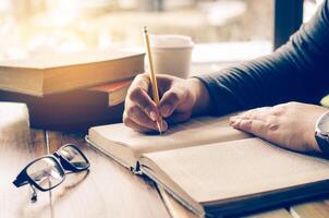 The woman's hands are writing notes in a notebook. photo