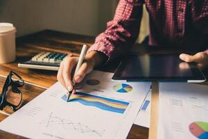Business people are working on accounts in business analysis with graphs and documentation. photo
