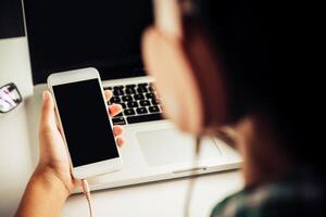 People are using a smartphone to listen to music and wear headphones. photo