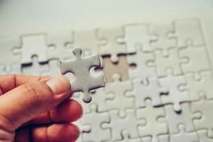 Handle a piece of white puzzles that are about to drop to get a complete worksheet - An attempt to succeed. photo