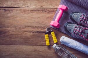 fitness concept with Exercise Equipment on wooden background. photo