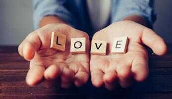 el palabra amor en manos en ahuecado forma. conceptos de intercambio, donación, foto