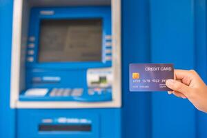 mano insertando con un crédito tarjeta dentro banco máquina . hombre utilizando un Cajero automático máquina con crédito tarjeta a retirar dinero foto