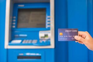 Hand inserting with a credit card into bank machine . Man using an atm machine with  credit card to withdraw money photo