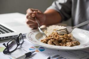 Business team is eating lunch at work while working photo