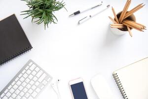 Top view with copy space, working desk with laptop,cell phone,notebook pencil and coffee on white background photo