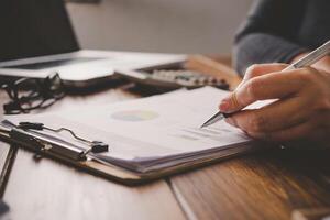 Business people are working on accounts in business analysis with graphs and documentation. photo