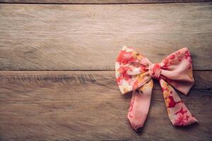 Top view of the women bow placed on a wooden floor. photo