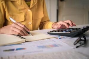 Businesswoman a working on accounts in business analysis with graphs and documentation. photo