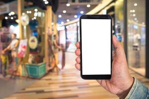 Mock up Blank screen smartphone in shopping mall background of blur background blurred indoors for lifestyle concept or co-working background. photo