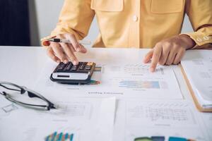 Businesswoman a working on accounts in business analysis with graphs and documentation. photo