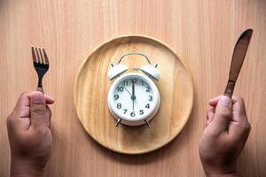 The clock is at  for lunch in a wooden dish. photo