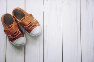 rojo Zapatos para niños en de madera piso foto