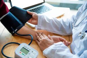 médico medición sangre presión desde su paciente foto