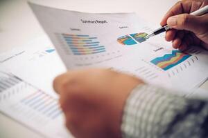 Business people are working on accounts in business analysis with graphs and documentation. photo
