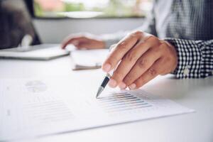 Business people are working on accounts in business analysis with graphs and documentation. photo