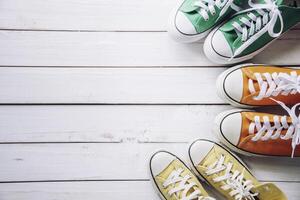 Sports shoes, work shoes, put on a white wooden floor - a living concept. photo