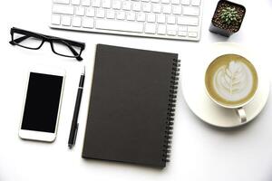 Top view with copy space, working desk with laptop,cell phone,notebook pencil and coffee on white background photo