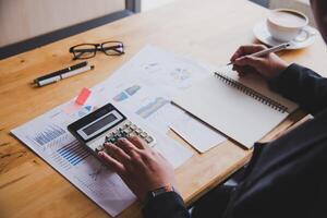 Business people are working on accounts in business analysis with graphs and documentation laptop in office photo