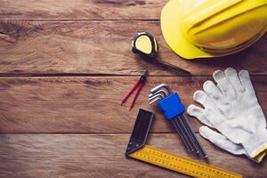 Safety helmet with safety equipment for work on wooden floor. photo