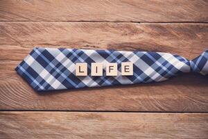 corbata y el mensaje En Vivo poner en de madera piso - concepto de vida. foto