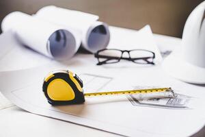 tape measure is placed on the work table with a house plan designed Including engineering equipment photo