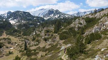 dois montanhistas caminhando em a vale do a cvrsnica montanha dentro Bósnia e herzegovina. neve em a picos do a montanha video