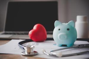 Medical Insurance Concept With Piggy Bank And Stethoscope On Wooden Desk photo