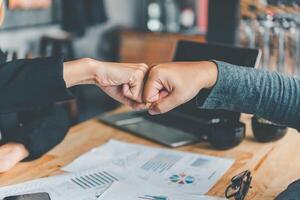Business colleagues making a fist bumpp are happy to work together successfully , Working in a reliable team photo