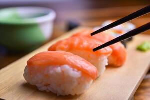 a comer Sushi utilizando palillos. foto