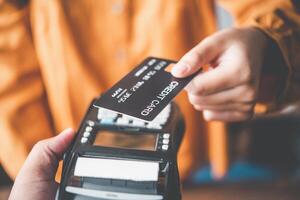 Close up of hand using credit card to pay by sending the credit card to the staff at the credit card swipe machine. Online payment photo