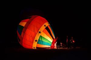 el equipo es preparando un globo con un fuego a hacer el globo elevar. foto