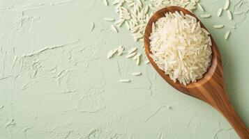 AI generated Uncooked white rice in wooden spoon on green textured background. Top view. Banner with copy space. Concept of cooking ingredient, healthy nutrition, cereal grain, and agricultura photo