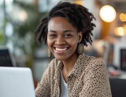 ai generado contento negro mujer utilizando ordenador portátil a trabajo en oficina, responsabilidad concepto foto