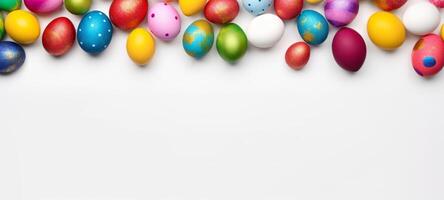 AI generated Vibrant Easter eggs in a variety of colors and patterns line the top of a white background. Ideal for festive season advertising and Easter celebration themes. Top view. Banner photo