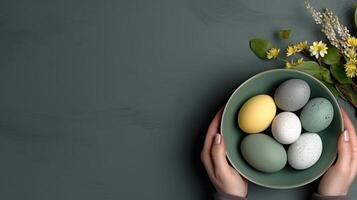 AI generated Hands holding bowl with colorful painted Easter eggs, against a dark green blue background with flowers. Top view. Banner with copy space. For Easter promotions or spring-themed photo