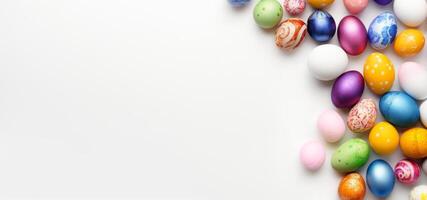 AI generated A variety of hand-painted Easter eggs against a white backdrop. Ideal for springtime marketing and holiday-themed graphic design. Top view. Banner with copy space. photo