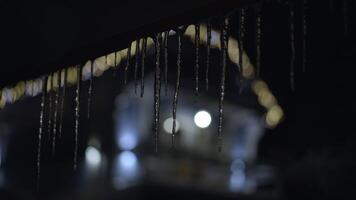 ijspegels hangen van de dak Aan een winter nacht video