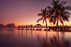 Amazing mood with poolside and palms next to beach and the ocean. Sunset sky and calm sea for luxury vacation tourism concept photo