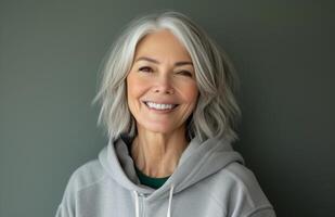 AI generated Beautiful senior woman smiles in a gray hoodie, latest fashion trends image photo