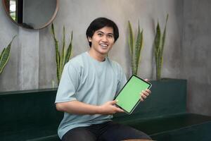 Potrait of Young Asian men holding a tablet PC in a cafe workplace with expressive faces photo