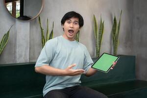 Potrait of Young Asian men holding a tablet PC in a cafe workplace with expressive faces photo