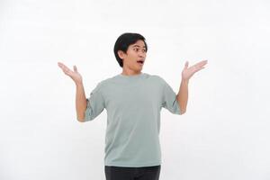 un joven asiático hombre levanta su mano con un confuso y despistado expresión foto