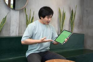 Potrait of Young Asian men holding a tablet PC in a cafe workplace with expressive faces photo