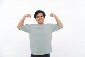 Young Asian Man Raises Hand, Expressing Strength with Varied Emotions from Smiles to Anger photo