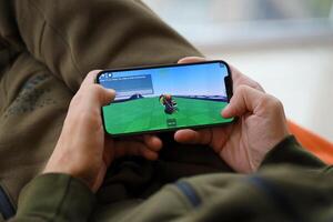 Roblox mobile iOS game on iPhone 15 smartphone screen in male hands during mobile gameplay photo